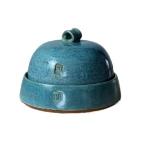 A blue ceramic bell with a lid Description automatically generated