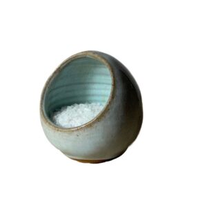 A small round bowl with a white salt inside Description automatically generated with medium confidence