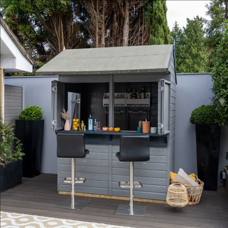 A small shed with stools and a table Description automatically generated