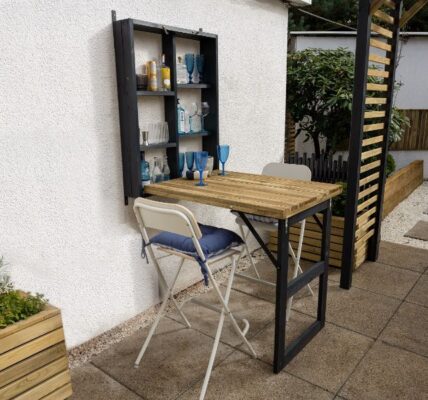 A table and chair outside a house Description automatically generated
