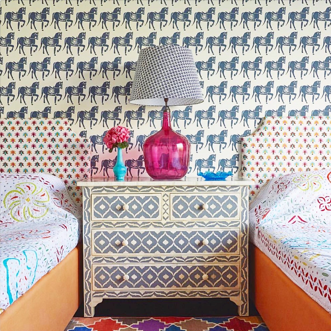 A dresser with a lamp and a vase on it Description automatically generated