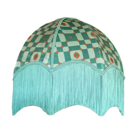 A green and orange shade with fringe Description automatically generated