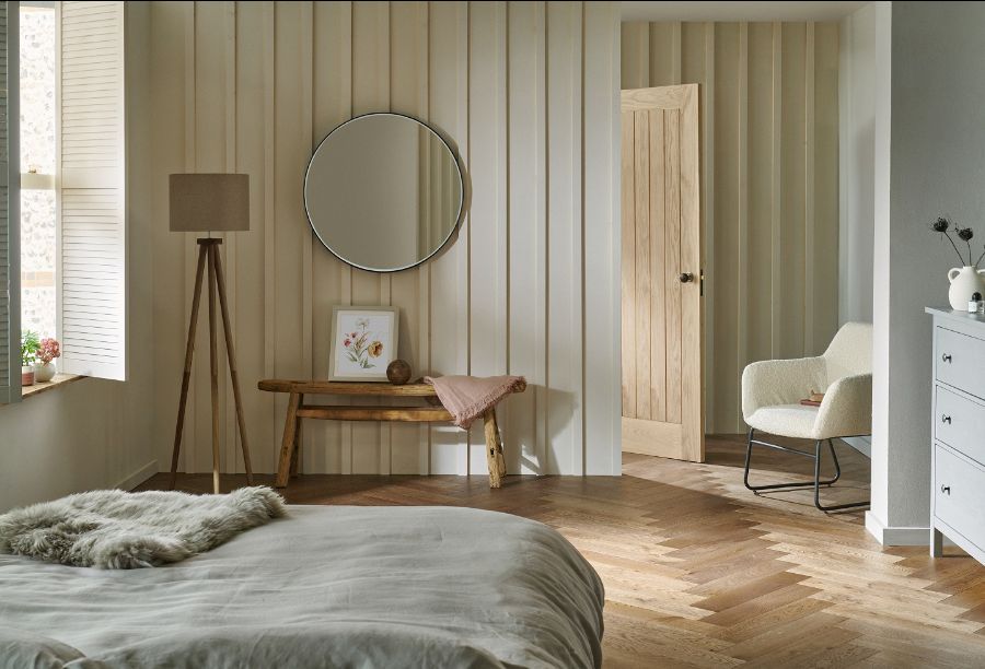 A bedroom with a mirror and a chair

Description automatically generated