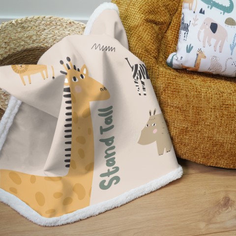 a comfy lookig blanket with a childlike animal design next to a beanbag seat