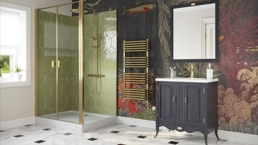 The image features a stylish bathroom with a contemporary design that incorporates brass elements. The focal point is a brushed brass dual fuel towel rail, which stands out against a dark, intricately patterned wallpaper that depicts a lush forest scene with hints of wildlife and florals in deep reds and greens. The shower enclosure showcases a geometric brass frame with clear glass, complementing the towel rail and adding a touch of modern luxury. The vanity unit is a classic dark wood with brass handles, contrasting the white basin above it and the white and black diamond patterned tile floor below. The space is well-lit, and there is a white-framed mirror above the vanity that reflects the natural light coming from the window. The overall aesthetic is one of elegance and warmth, with the brass accents lending a timeless yet trendy feel to the bathroom, exemplifying how brass fixtures can add sophistication to a home.