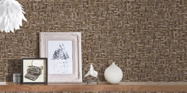 a wallpaper showing a woven effect. A shel;f onbthe wall holds some photographs and ornaments