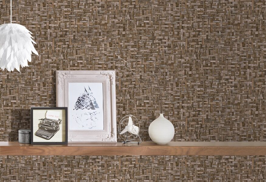 a wallpaper showing a woven effect. A shel;f onbthe wall holds some photographs and ornaments