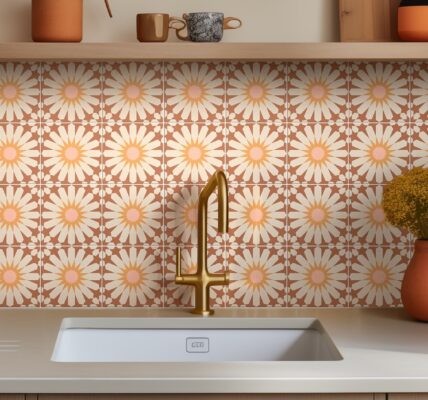 A kitchen sink with a faucet and a vase of flowers on the counter.