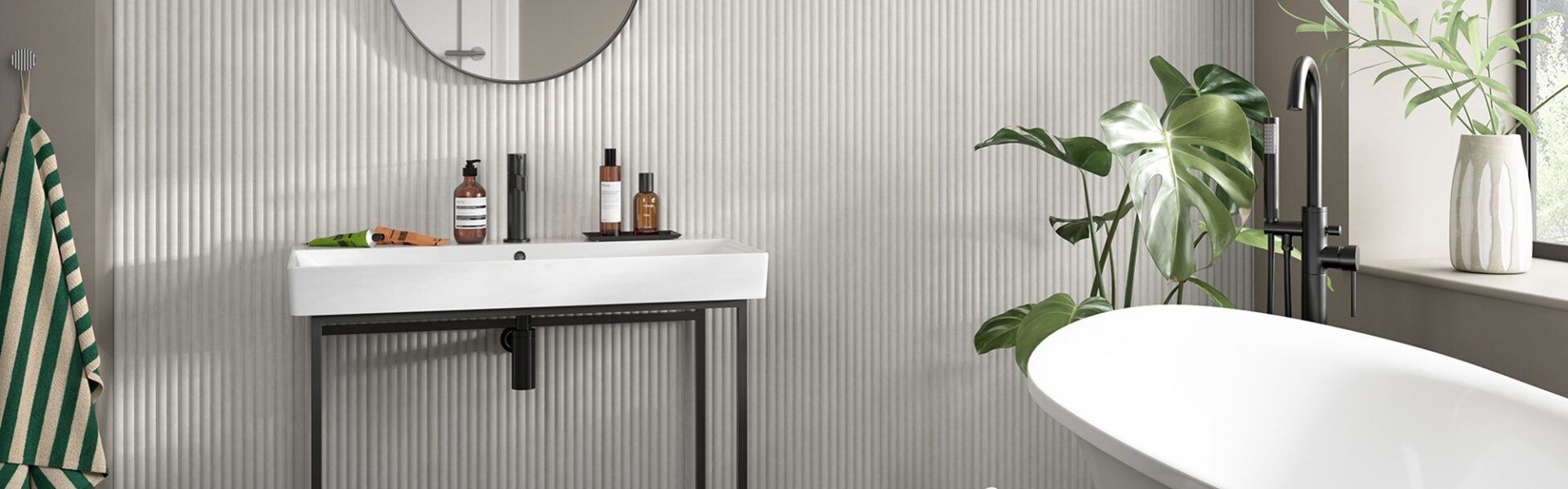 A small bathroom featuring modern reeded wooden wall-panelling with a white sink, mirror, and bathtub.
