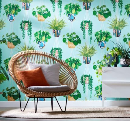 A modern room with a chair in front of a patterned wallpaper featuring white hanging planters.