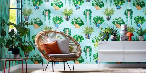 A modern room with a chair in front of a patterned wallpaper featuring white hanging planters.