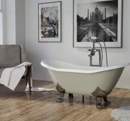 A white clawfoot bathtub with rolled edges sits in a bathroom with patterned tile floors. A wooden chair with a towel draped over it sits beside the bathtub.