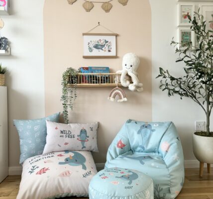 A cosy room with a beanbag chair, ottoman, and pillows.