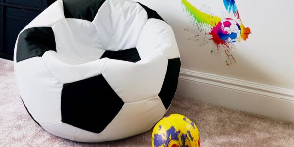 White soccer ball bean bag chair on floor next to soccer ball
