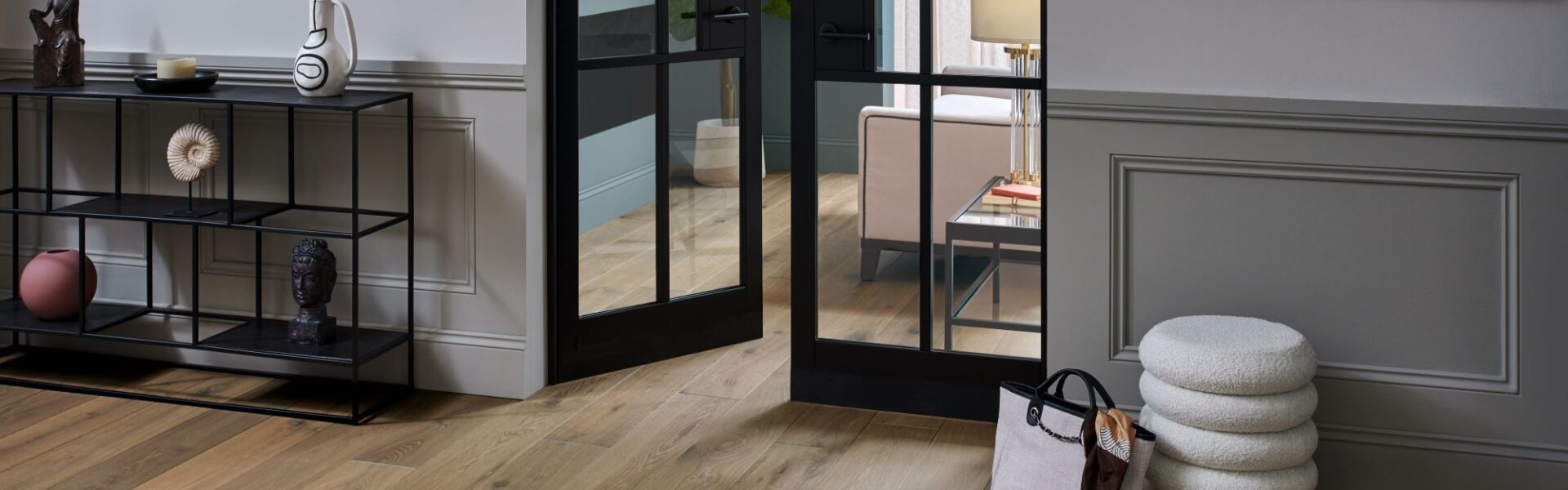 Living space with wooden floor and closed door at the end