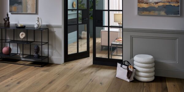 Living space with wooden floor and closed door at the end