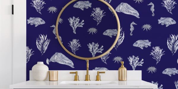 Bathroom with blue patterned wallpaper and a gold framed mirror