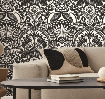 A detailed portion of wallpaper, highlighting an intricate pattern of large, exotic leaves in various shades.