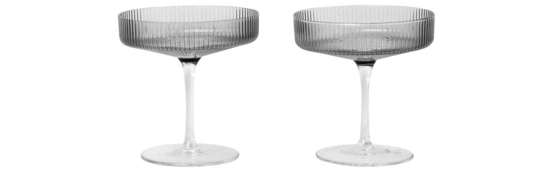 Two smoked grey champagne glasses on a white background.