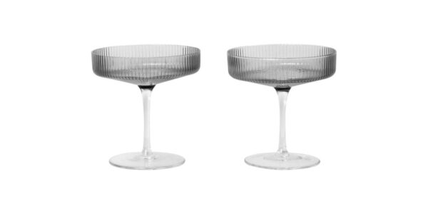 Two smoked grey champagne glasses on a white background.