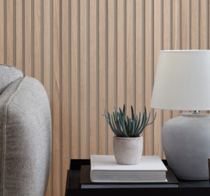 A wood panelled wall with a white lamp and a grey sofa
