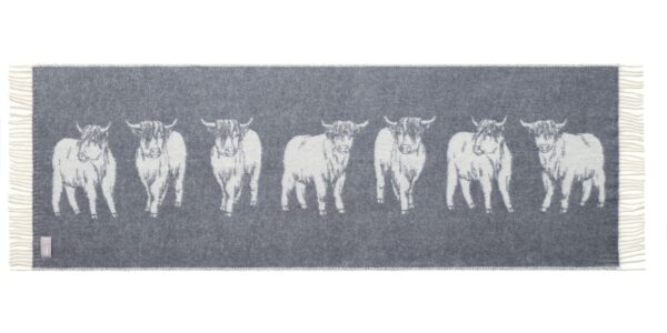 The image shows a Highland Cow Bed Runner. The distinctive shaggy coat and long horns of the cows are seen clearly. It's a charming and cosy addition to any home.