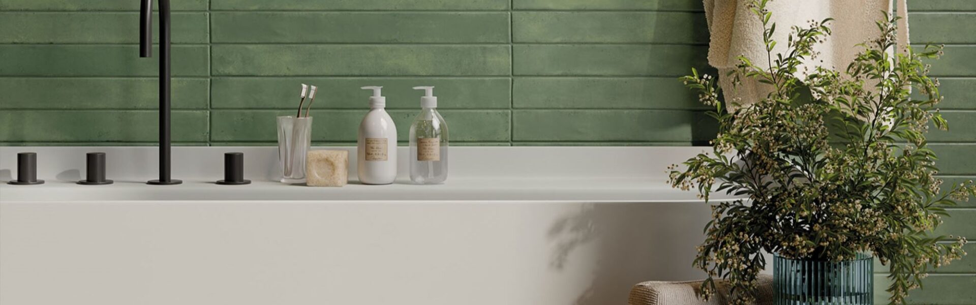 The image shows a modern bathroom with a white bathtub, a green tiled wall, and a variety of accessories, including a plant, towels, and a soap dispenser. The overall aesthetic is clean, minimalist, and inviting.