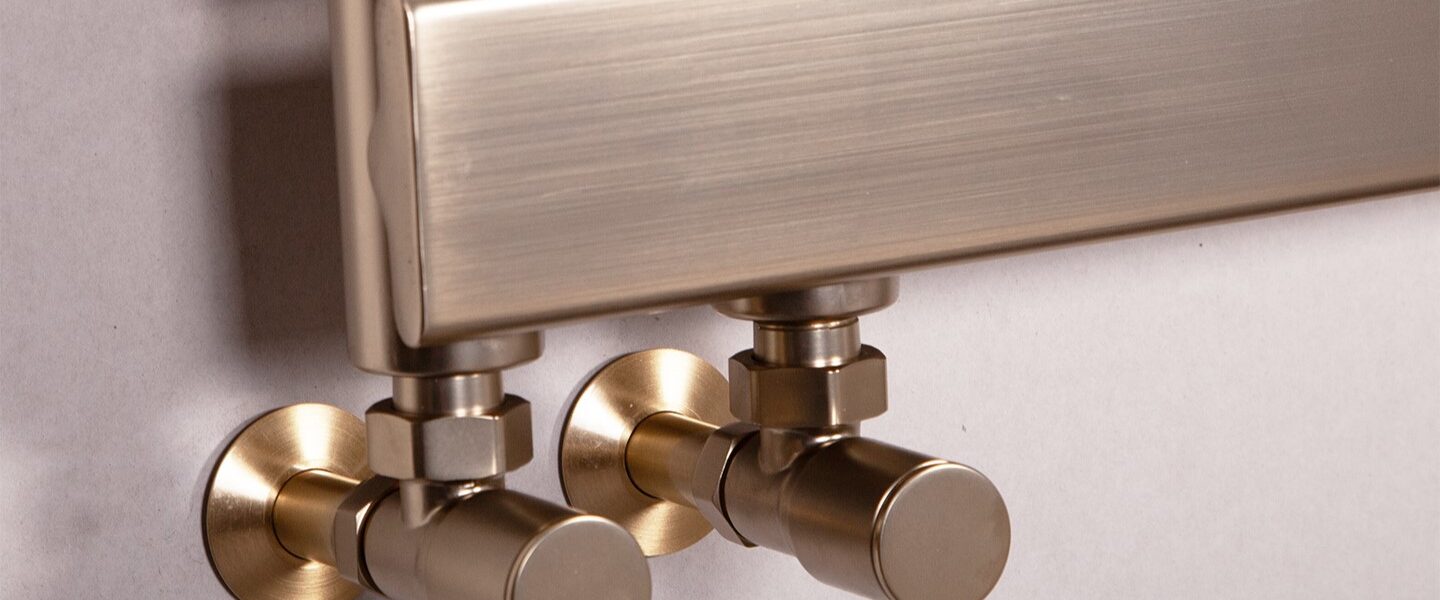 Luxurious brushed brass heated towel rail with stylish round valves