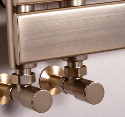 Luxurious brushed brass heated towel rail with stylish round valves