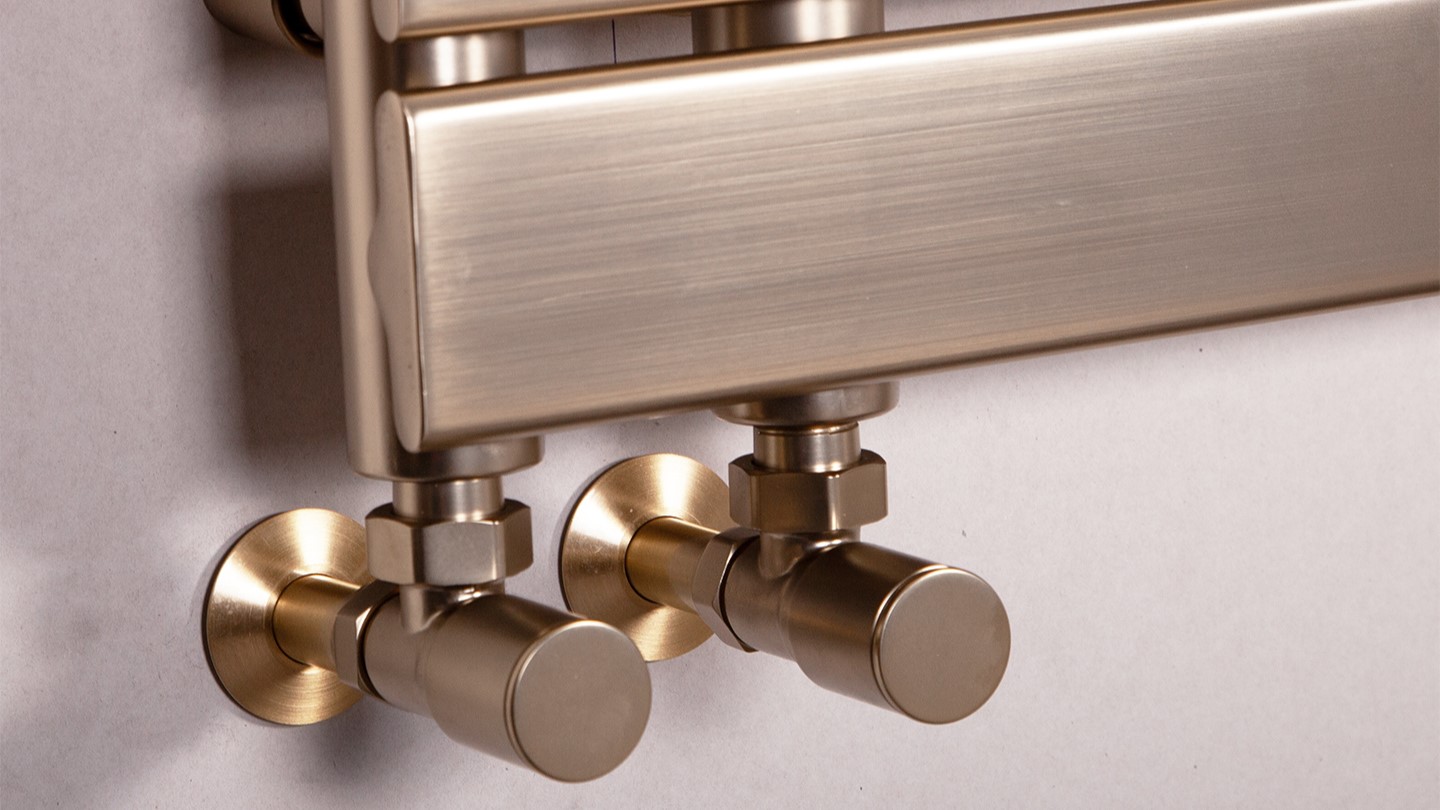 Luxurious brushed brass heated towel rail with stylish round valves