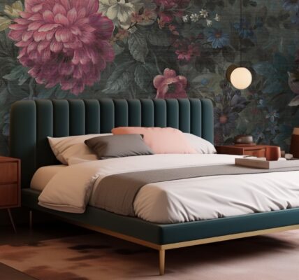 A bedroom with a large floral wallpaper featuring peonies and other flowers, a green velvet bed with gold accents, and a pink bedside table.