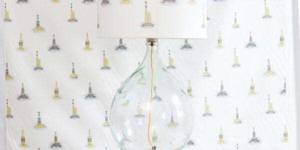 Made from a large, clear glass bottle. The bottle has a rounded, bulbous shape, giving it a distinctive look. The base is likely repurposed from a wine or liquor bottle.