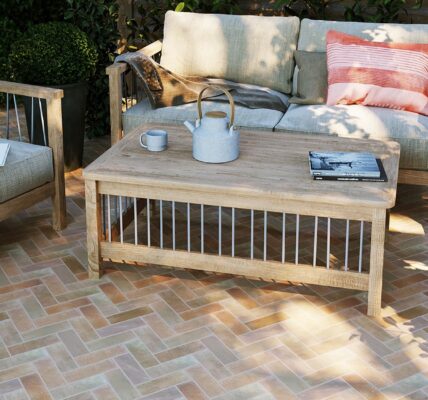 The patio features herringbone-patterned terracotta tiles in warm, earthy tones, creating a visually appealing surface.
