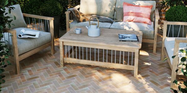 The patio features herringbone-patterned terracotta tiles in warm, earthy tones, creating a visually appealing surface.