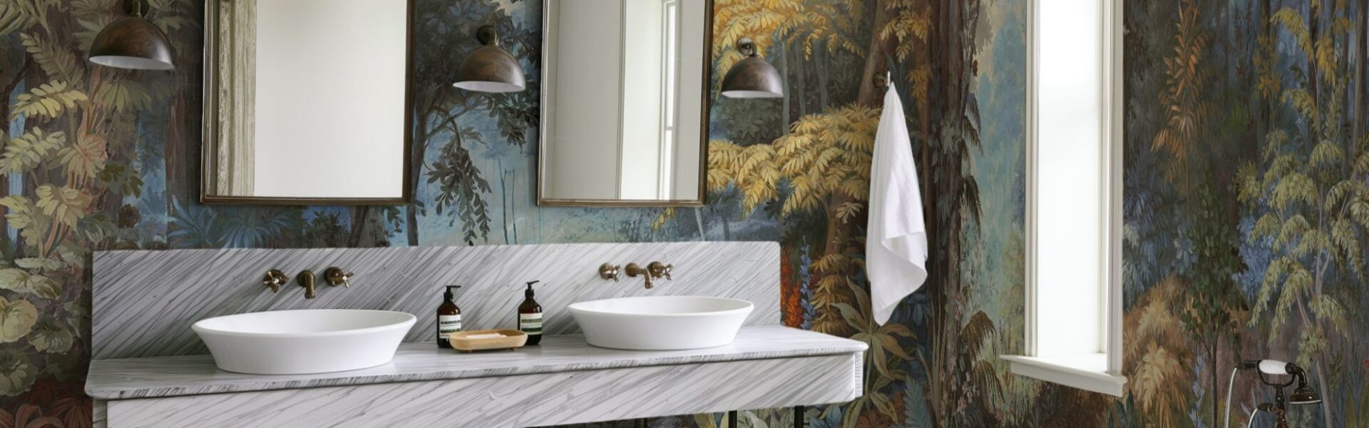 The wallpaper features a nature-inspired mural with trees and foliage in various shades of blue, green, brown, and yellow. This creates a strong visual impact and adds depth to the room.