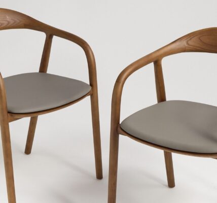 A pair of contemporary wooden dining chairs with curved backs and grey upholstered seats.