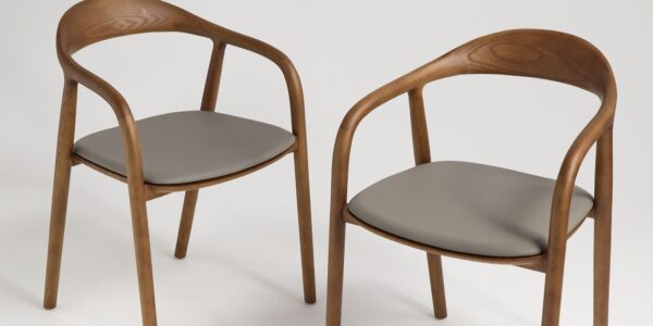 A pair of contemporary wooden dining chairs with curved backs and grey upholstered seats.