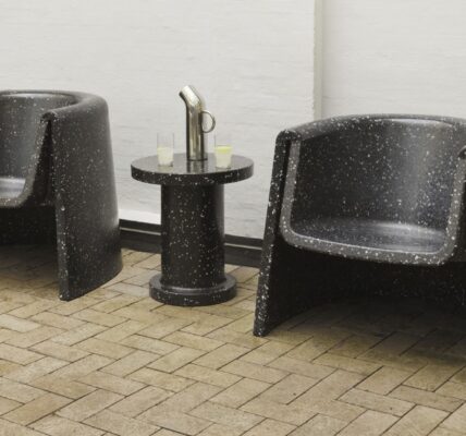 The distinctive cylindrical shape with the speckled texture is characteristic of the Bit series designed by Simon Legald for Normann Copenhagen. You can see two lounge chairs and a smaller side table in the same style.