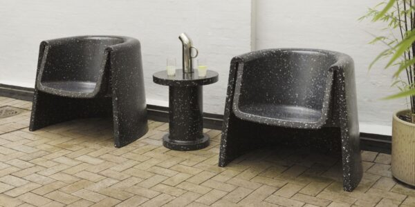 The distinctive cylindrical shape with the speckled texture is characteristic of the Bit series designed by Simon Legald for Normann Copenhagen. You can see two lounge chairs and a smaller side table in the same style.