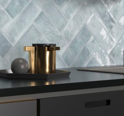 The backsplash features light blue or grey tiles arranged in a herringbone pattern. The tiles have a distinctive textured, almost wavy or rippled surface, giving them a handmade or artisanal appearance.