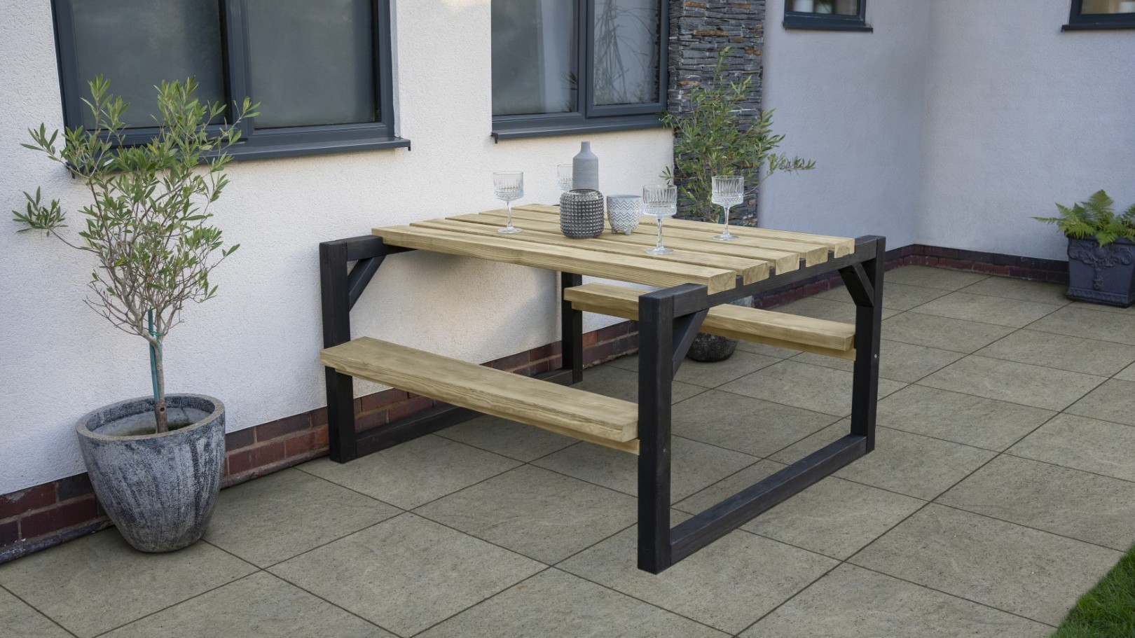 A wooden picnic table and attached benches on a patio, perfect for summer dining.
