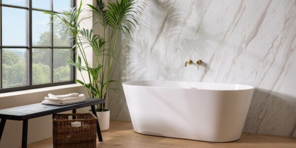 : A bright and airy bathroom featuring a freestanding white oval bathtub positioned in front of a wall with a light marble pattern.
