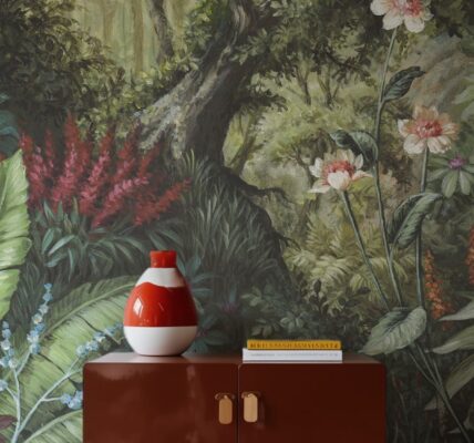 A detailed wallpaper mural depicting a lush, verdant forest scene. A tree trunk dominates the centre, surrounded by a variety of green foliage, red and white flowers.