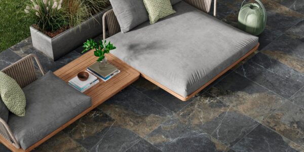 A luxurious outdoor living space featuring dark, multi-toned patio tiles.