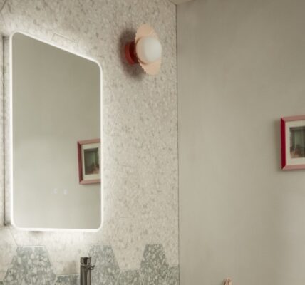 A rectangular mirror with a light glow around the border brings an ethereal feel to bathrooms