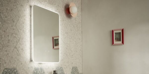 A rectangular mirror with a light glow around the border brings an ethereal feel to bathrooms