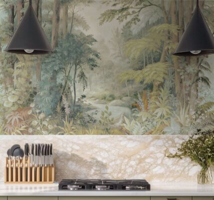 A modern kitchen featuring a forest-themed mural wallpaper, a marble backsplash, and two black pendant lights.