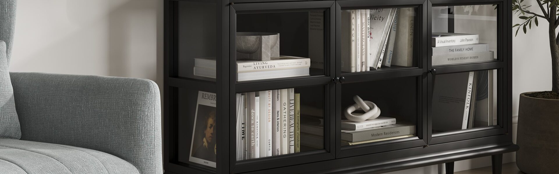 A sleek, modern black sideboard with three glass-fronted doors, each revealing two shelves filled with books and decorative objects.
