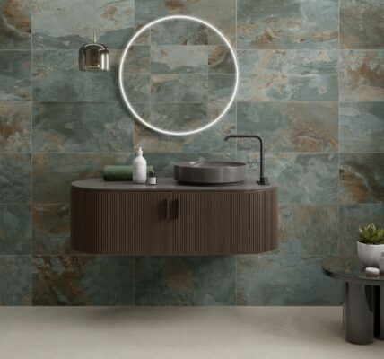 A modern bathroom featuring walls tiled with Strata Green tiles. The tiles have a distressed, multi-tonal appearance with shades of green, brown, and grey.