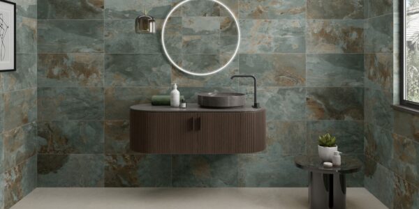 A modern bathroom featuring walls tiled with Strata Green tiles. The tiles have a distressed, multi-tonal appearance with shades of green, brown, and grey.